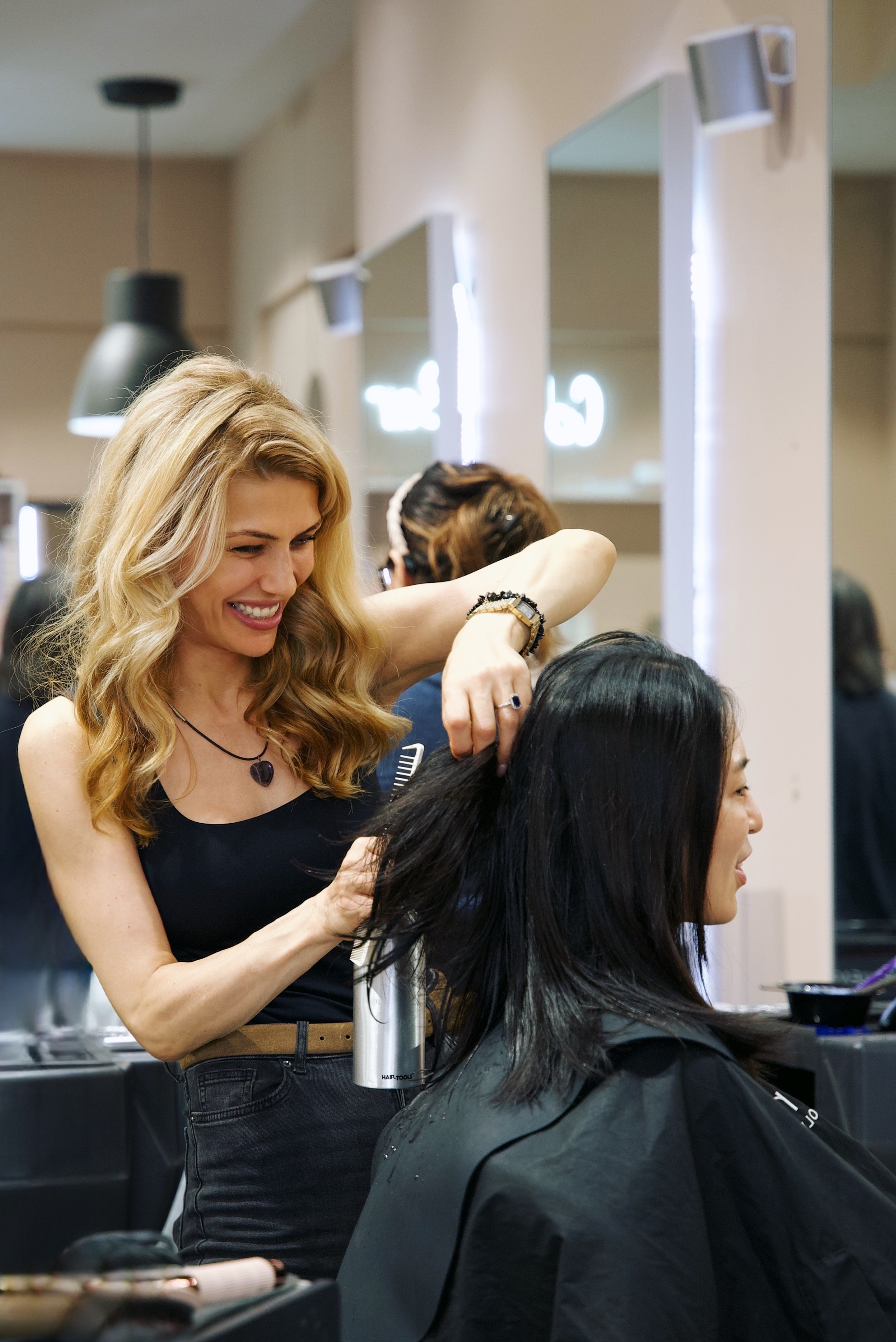 A stylist blow-drying and styling a client's hair