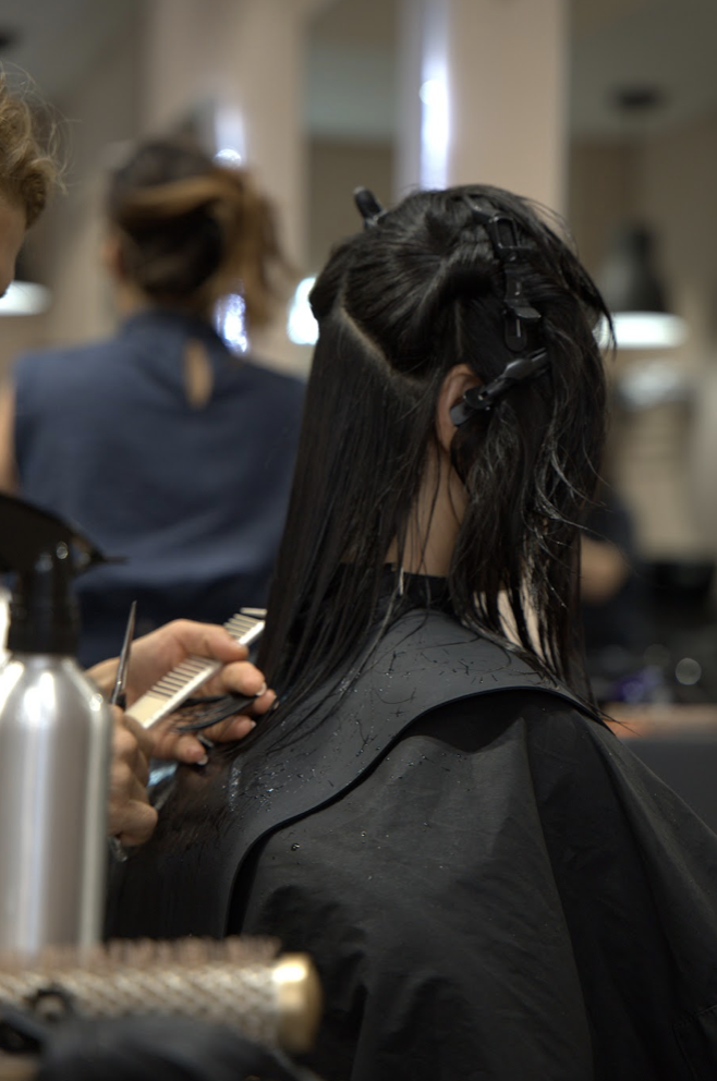 A stylist sectioning and cutting a client's hair